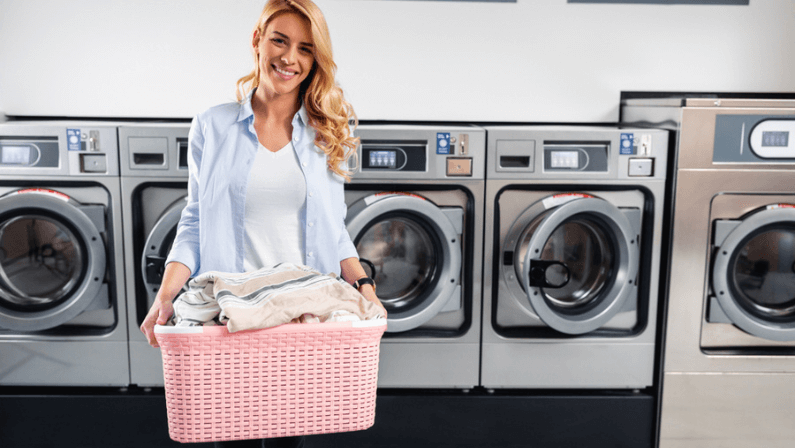 Shot of a young woman doing his weekly washing in a laundromat