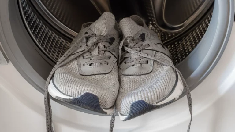 Unrecognizable man washing shoes at industrial laundromat