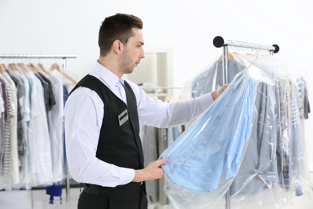 Young man working in drycleaning salon