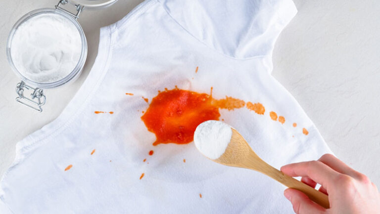 A female's hand removing stain on clothes with baking soda. Ruined clothes. top view. isolated. The concept ecological cleaning and removing stains. High quality photo