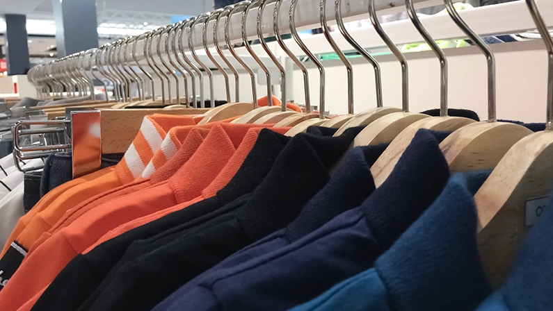 A row of colorful clothes hanging on the rack