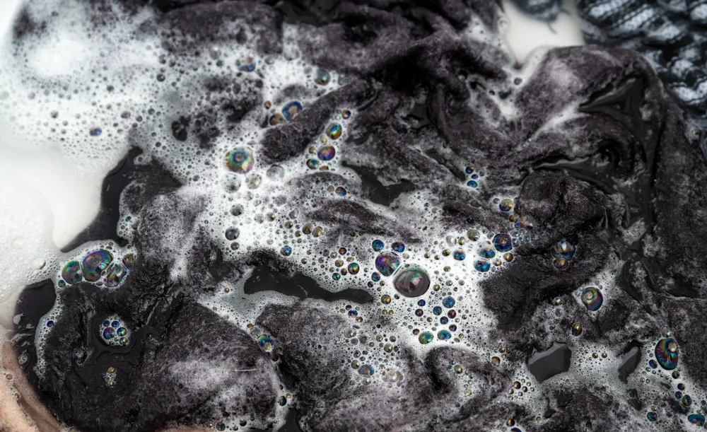 Cashmere Sweater Being Hand Washed in Soapy Water
