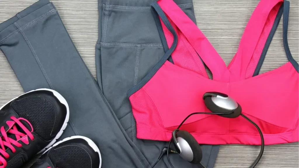 Gym outfit - workout clothing, running shoes, headphones and smartphone to listen to music while working out at the fitness center.