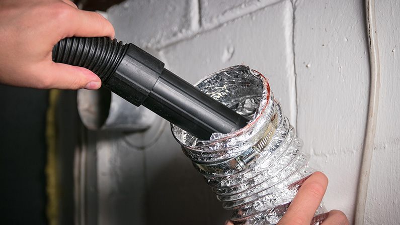 Vacuum cleaning a flexible aluminum dryer vent hose, to remove lint and prevent fire hazard.