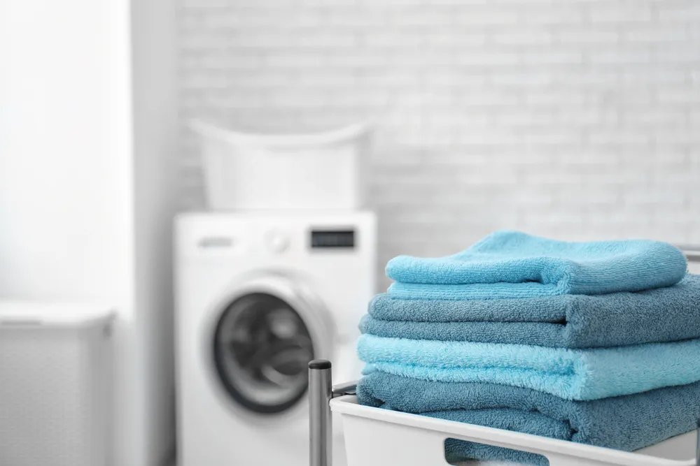 Stack of clean towels on cart in laundromat