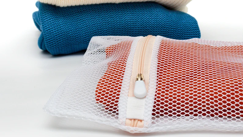 Knitwear in a bag for delicate washing of fabrics. The concept of gentle washing of clothes, fabrics.