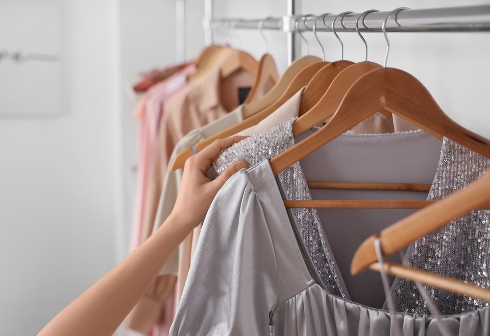 Young woman choosing dress for prom night in dressing room, closeup