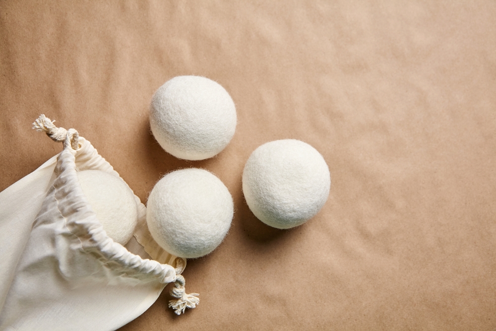 Wool dryer balls placed beside a cotton drawstring bag