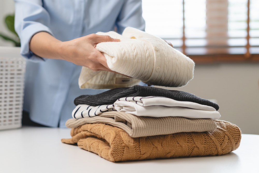 Laundry household work concept, asian woman working on fresh clean clothes.