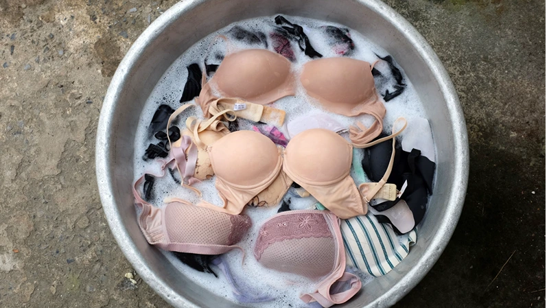 bra or underwear,undergarment,brassiere in stainless steel basin on the cement floor.dry cleaning concept, care for clothes